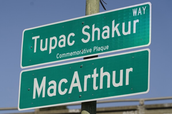 A new sign is seen following a street renaming ceremony for Tupac Shakur in Oakland, Calif., Friday, Nov. 3, 2023. A stretch of street in Oakland was renamed for Shakur, 27 years after the killing of the hip-hop luminary. A section of Macarthur Boulevard near where he lived in the 1990s is now Tupac Shakur Way, after a ceremony that included his family members and Oakland native MC Hammer. (AP Photo/Eric Risberg)