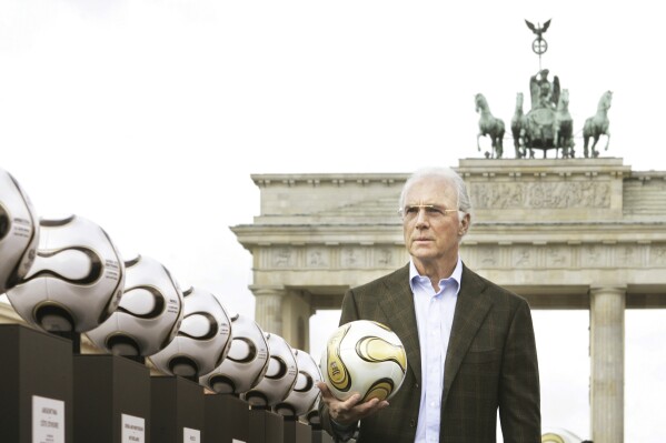 FILE - German soccer legend Franz Beckenbauer, head of Germany's organising committee for the soccer World Cup, plays with the Golden Ball for the World Cup in front of the Brandenburg Gate in Berlin, on April 18, 2006. Germany's World Cup-winning coach Franz Beckenbauer has died. He was 78. Beckenbauer was one of German soccer's central figures. He captained West Germany to the World Cup title in 1974. He also coached the national side for its 1990 World Cup win against Argentina. (AP Photo/Jan Bauer, File)