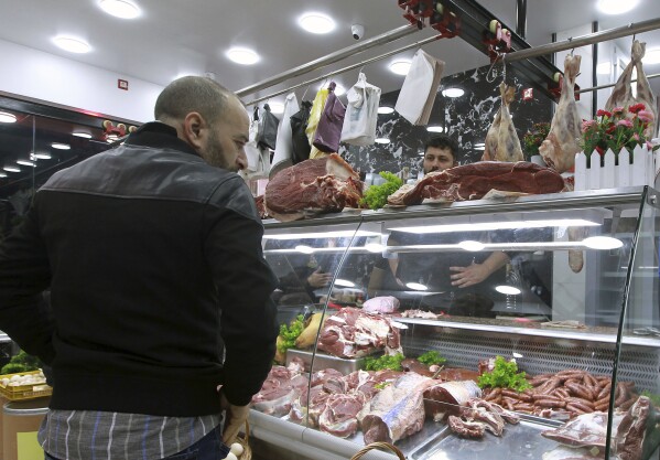 People shop for beef at a butchery in Algiers, Algeria, Sunday, Feb. 18, 2024. Algeria is importing massive amounts of beef and lamb to confront an explosion in demand for meat expected throughout the Muslim holy month of Ramadan, hoping to stabilize prices as the country's economy continues to struggle. The oil-rich North African nation is among countries working to import food and fuel, hoping to meet the requirements of Algerians preparing nightly feasts as their families break their sunrise-to-sunset fasts. (AP Photo/Fateh Guidoum)