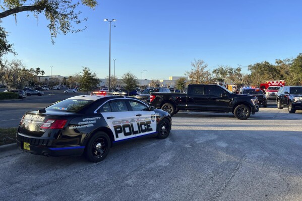 In this photo provided by the Ocala Police Department, a cruiser is parked after a fatal shooting at the Paddock Mall in Ocala, Florida, about 80 miles northwest of Orlando, on Saturday, Dec. 23, 2023.  (Jeff Walczak/Ocala Police Department) via AP)