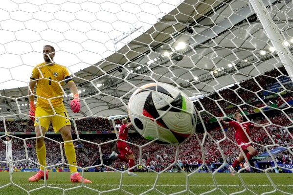 Denmark's Christian Eriksen, center, celebrates scoring the opening goal s during a Group C match between Slovenia and Denmark at the Euro 2024 soccer tournament in Stuttgart, Germany, Monday, June 17, 2024. (AP Photo/Matthias Schrader)