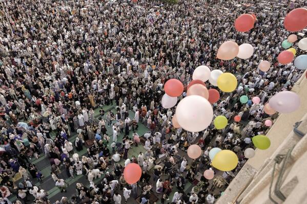 Balloons are distributed for free after Eid al-Fitr prayers, marking the end of the Muslim holy fasting month of Ramadan outside al-Seddik mosque in Cairo, Egypt, Friday, April 21, 2023. (AP Photo/Amr Nabil)