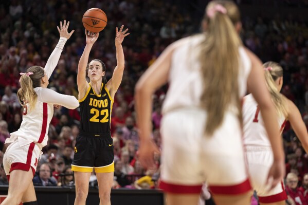 Iowa's Caitlin Clark, second from left, shoots against Nebraska's Kendall Moriarty, left, during the second half of an NCAA college basketball game Sunday, Feb. 11, 2024, in Lincoln, Neb. (AP Photo/Rebecca S. Gratz)