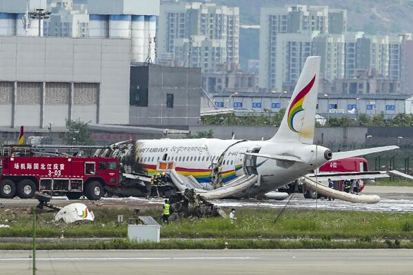 In this photo released by Xinhua News Agency, a passenger jet that veered off a runway during take-off and caught fire is seen in the aftermath in Chongqing Jiangbei International Airport in southwestern China's Chongqing Thursday, May 12, 2022. The Chinese passenger jet left the runway upon takeoff and caught fire in western China on Thursday morning, and several people were injured. (Liu Chan/Xinhua via AP)
