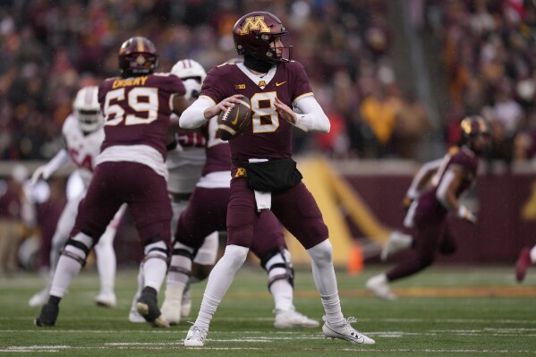 Minnesota quarterback Athan Kaliakamanis (8) looks to pass during the first half of an NCAA college football game against Wisconsin on Saturday, Nov. 25, 2023, in Minneapolis.  (AP Photo/Abby Parr)