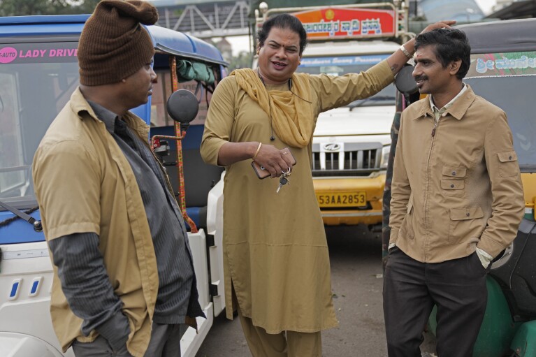 Preethi chats with fellow auto rickshaw drivers as she waits for customers to ferry in her electric auto rickshaw in Bengaluru, India, Wednesday, July 12, 2023. (AP Photo/Aijaz Rahi)