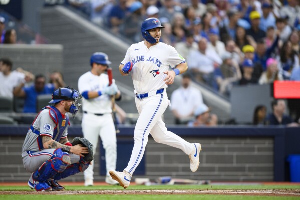Toronto Blue Jays' Spencer Horwitz, right, scores against the Texas Rangers during first-inning baseball game action in Toronto, Friday, July 26, 2024. (Christopher Katsarov/The Canadian Press via ĢӰԺ)