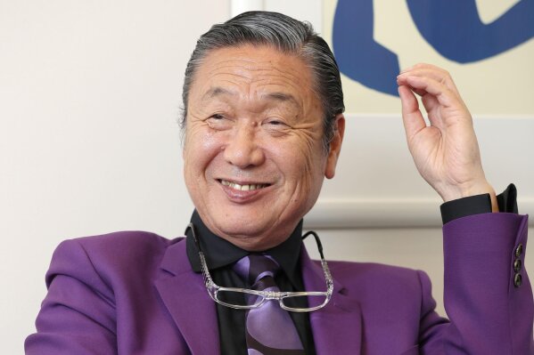 Japanese fashion designer Kansai Yamamoto speaks during an interview in Tokyo, in May, 2017.  Yamamoto, known for his avant-garde and colorful work that included flamboyant costumes of the late rock icon David Bowie has died of leukemia, his company said on Monday, July 27, 2020. He was 76.(Kyodo News via AP)