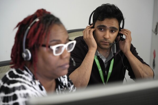 Meharry Medical College student Mikhail Thanawalla, right, watches and listens as Sonya Smith, a referral screening specialist, takes a call at the Tennessee Donor Services headquarters June 15, 2023, in Nashville, Tenn. The many steps to successful donation “are like gears in a machine and the entire machine breaks down if one gear fails. That’s my biggest takeaway,” says Thanawalla of Scottsbluff, Neb. (AP Photo/Mark Humphrey)