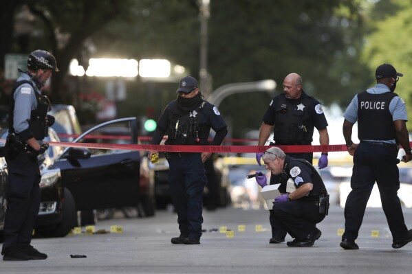 FILE - In this Aug. 4, 2020, file photo, Chicago police investigate the scene of a shooing in Chicago. A federal jury on Wednesday, Jan. 17, 2024, has convicted six alleged gang members in the 2020 fatal shooting of Chicago rapper FBG Duck, a killing that prosecutors said was part of long-running violence over gang territories on the city’s South Side. (Chris Sweda/Chicago Tribune via AP)