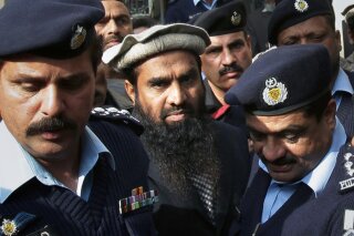 FILE - In this Thursday, Jan. 1, 2015, file photo, Pakistani police officers escort Zaki-ur-Rehman Lakhvi, center, the main suspect of the Mumbai terror attacks in 2008, after his court appearance in Islamabad, Pakistan. Pakistan's security forces arrested Saturday, Jan. 2, 2021 an alleged leader of the militant group that was behind the bloody 2008 Mumbai attacks in India. (AP Photo/B.K. Bangash, File)