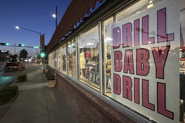 A sign in support of the oil and natural gas industry is displayed in a shop window along a main street in Carlsbad, N.M., on Tuesday, May 20, 2025. (AP Photo/Susan Montoya Bryan)