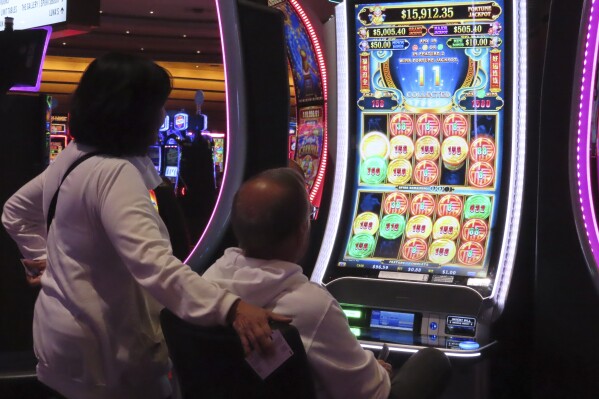 A gambler plays a slot machine at the Ocean Casino Resort in Atlantic City, N.J. on Nov. 29, 2023. Internet gambling and sports betting both set new records in November as gamblers continue to take advantage of more options in addition to traveling to physical casinos in order to wager. (AP Photo/Wayne Parry)