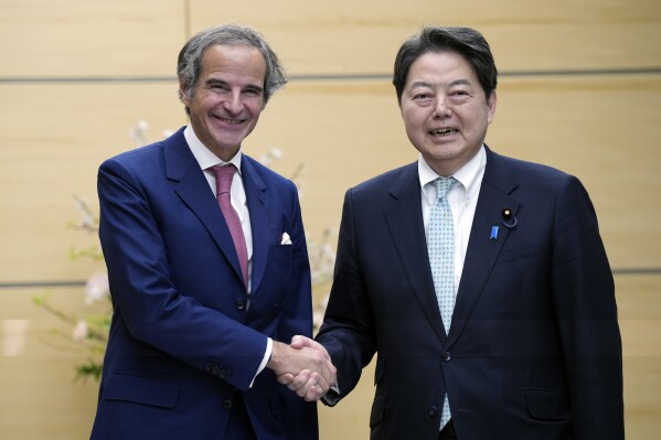 International Atomic Energy Agency Director General Rafael Mariano Grossi, left, and Japan's Chief Cabinet Secretary Yoshimasa Hayashi, right, shake hands during their meeting at the prime minister's office Tuesday, March 12, 2024, in Tokyo. (AP Photo/Eugene Hoshiko, Pool)