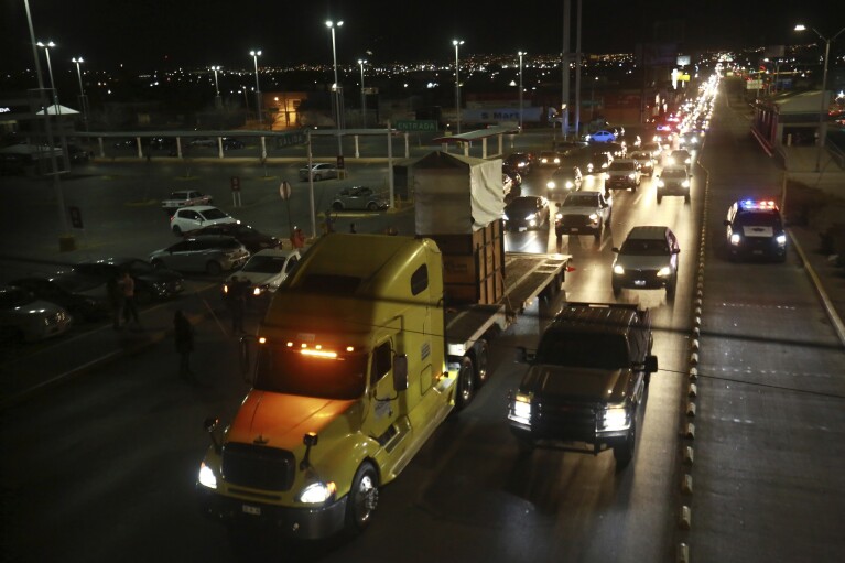 Um caminhão que transportava a girafa Benito é escoltado por um comboio de veículos com policiais do Ministério Público Federal de Proteção Ambiental e da Guarda Nacional em Ciudad Juarez, México, domingo, 21 de janeiro de 2024. (AP Photo/Christian Chavez)