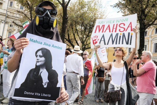 Protesters demonstrate on the occasion of the one-year anniversary of the death of 22-year-old Mahsa Amini, in Rome, Saturday, Sept. 16, 2023. Amini died following her arrest by the Iran's morality police for allegedly violating the country's mandatory headscarf rule. Writing on poster reads in Italian 