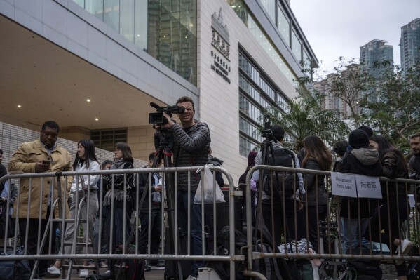 Journalists wait at a designated press area outside West Kowloon Magistrates' Courts where Jimmy Lai's trial will be held in Hong Kong, Monday, Dec. 18, 2023. (AP Photo/Vernon Yuen)