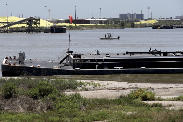 A Texas Parks & Wildlife Department boat monitors the Galveston Ship Channel where a barge collided with an old rail bridge on the Pelican Island Bridge in Galveston, Texas on Wednesday, May 15, 2024. The collision shut down the only road access to and from Pelican Island. (Jennifer Reynolds/The Galveston County Daily News via AP)