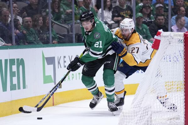 Dallas Stars left wing Jason Robertson (21) works to gain control of the puck while under pressure from Nashville Predators defenseman Ryan McDonagh (27) in the first period of an NHL hockey game, Monday, April 3, 2023, in Dallas. (AP Photo/Tony Gutierrez)