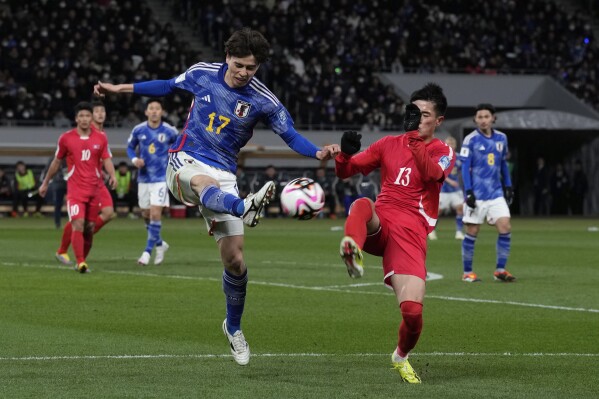 North Korea's Ri Il Song, right, competes for the ball with Japan's Ao Tanaka during the FIFA World Cup 2026 and AFC Asian Cup 2027 preliminary joint qualification round 2 match between Japan and North Korea at the National Stadium Thursday, March 21, 2024, in Tokyo. (AP Photo/Eugene Hoshiko)