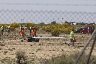 Emergency service members work in the area where an F-18 fighter jet crashed in Zaragoza, Spain, Saturday, May 20, 2023. An F-18 fighter jet crashed at an airbase in the Spanish city of Zaragoza but the pilot ejected successfully, the Spanish defense ministry said Saturday. The aircraft landed within the perimeter of the base, the defense ministry said on Twitter. (Fabian Simon/Europa Press via AP)