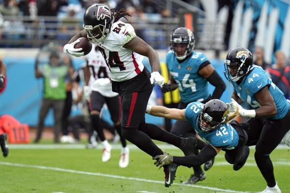 Atlanta Falcons running back Cordarrelle Patterson (84) dives over the goal line for a touchdown past Jacksonville Jaguars safety Andrew Wingard (42), linebacker Damien Wilson (54) and linebacker Myles Jack (44) during the first half of an NFL football game, Sunday, Nov. 28, 2021, in Jacksonville, Fla. (AP Photo/Chris O'Meara)