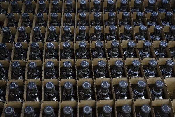 Bottles of product are stored in crates in the bottling area of The Bard Distillery in Graham, Ky., Sunday, March 9, 2025. (AP Photo/Jon Cherry)