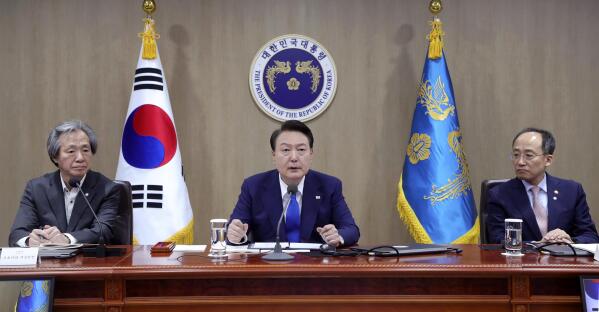 South Korean President Yoon Suk Yeol, center, speaks during a meeting of the Central Disaster and Safety Countermeasures Headquarters about measures to deal with the coronavirus pandemic at the presidential office in Seoul, South Korea, Thursday, May 11, 2023. South Korea will drop its COVID-19 quarantine requirements and end testing recommendations for international arrivals starting next month after the World Health Organization declared the end of the global health emergency. (Yonhap via AP)