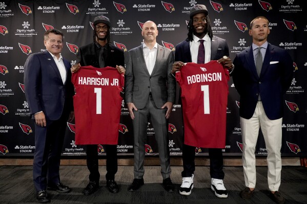 From left; Arizona Cardinals President and CEO Michael Bidwill, first round draft pick Marvin Harrison Jr., general manager Monti Ossenfort, first round draft pick Darius Robinson, and head coach Jonathan Gannon pose for a photographers at an NFL football press conference, Friday, April 26, 2024, at the teams' facility in Tempe, Ariz. (AP Photo/Matt York)