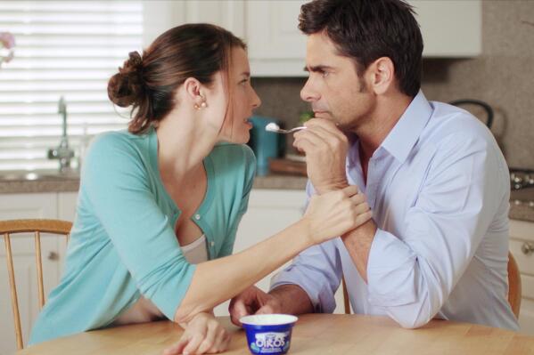 This advertisement provided by Dannon Co,. shows a scene from the Dannon Oikos Greek Yogurt Super Bowl commercial, starring Jessica Blackmore and John Stamos. The Dannon Oikos advertisement will run during the third quarter of Super Bowl XLVI, Sunday, Feb 5, 2012. About 20 of the roughly 36 Super Bowl advertisers put their TV commercials online in the days leading up to Sunday's broadcast. That's a big break with tradition and up from last year when only a handful of companies released their ads before the game. Stamos' Dannon ad is one of the ads that have been pre-released. (AP Photo/Dannon Co.)
