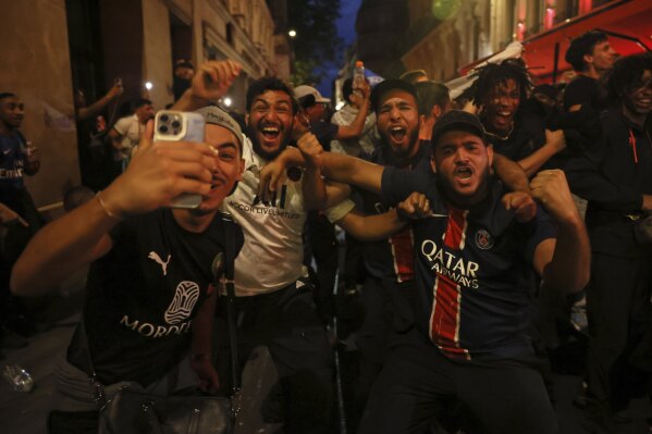 PSG supporters celebrate in a street during the Champions League final soccer match between Paris Saint-Germain and Inter Milan, Saturday, May 31, 2025 in Paris. (AP Photo/Thomas Padilla)