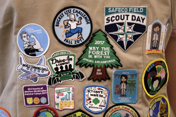 FILE - Patches cover the back of a Girl Scout's vest at a demonstration of some of their activities in Seattle, June 18, 2018. A federal judge, Thursday, April 7, 2022, tossed out a lawsuit in which the Girl Scouts claim that the Boy Scouts are creating marketplace confusion and damaging their recruitment efforts through their use of words such as "scouts" and "scouting." (AP Photo/Elaine Thompson, File)