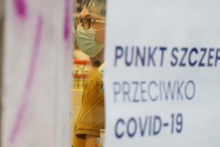 A person is administered a vaccination against COVID-19 in Warsaw, Poland, on Friday Nov. 26, 2021. Poland is facing skyrocketing COVID-19 infections and deaths but for now the government does not plan any new lockdowns or other restrictions. (AP Photo/Czarek Sokolowski)