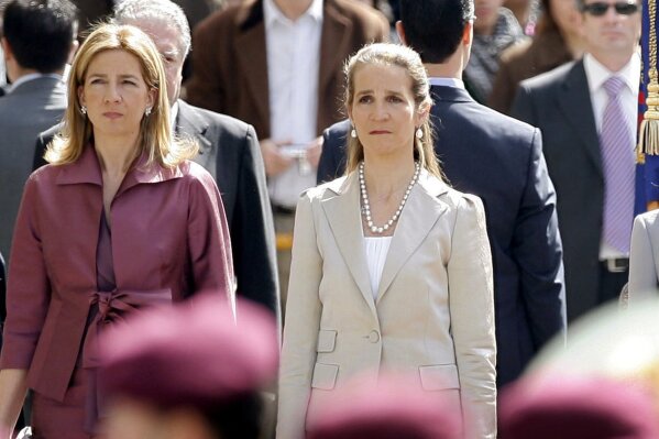 FILE - In this Wednesdday, April 16, 2008 file photo, Spain's Princess Cristina, left and Princess Elena, listen to the Spanish national anthem during a ceremony, upon their arrival for the opening of the Spanish Parliament, after Jose Luis Rodriguez Zapatero's Socialist Party won the general elections on March 9, in Madrid. The sisters of Spanish King Felipe VI have acknowledged on Wednesday, March 3, 2021, that they were administered COVID-19 vaccines during a visit to the United Arab Emirates. In a statement published by a Spanish newspaper, the Infantas Elena and Cristina said that they were “offered the possibility” of receiving vaccines while in Abu Dhabi to visit their father and former monarch, Juan Carlos I.  (AP Photo/Daniel Ochoa de Olza, File)