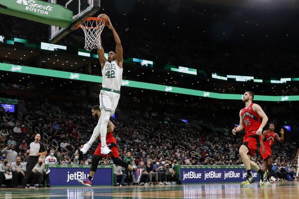 Boston Celtics' Al Horford (42) goes in for a dunk past Toronto Raptors' Svi Mykhailiuk (14) during the second quarter of an NBA preseason basketball game Saturday, Oct. 9, 2021, in Boston. (AP Photo/Winslow Townson)