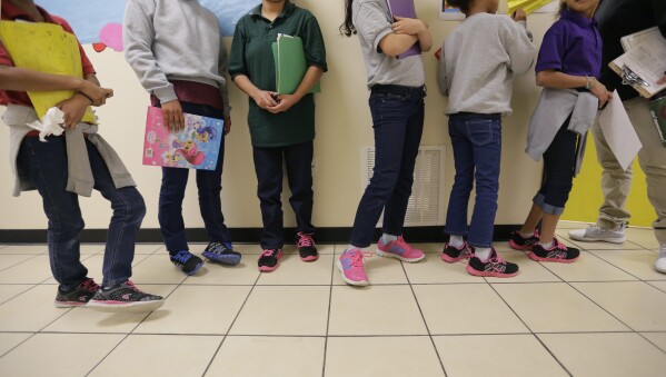 FILE - Migrant teens line up for a class at a "tender-age" facility for babies, children and teens, in Texas' Rio Grande Valley, in San Benito, Texas, Aug. 29, 2019. The Biden administration struggled to properly vet and monitor the homes where they placed a surge of migrant children who arrived at the U.S.-Mexico border in 2021. That's according to a federal watchdog report released Thursday. (AP Photo/Eric Gay File)