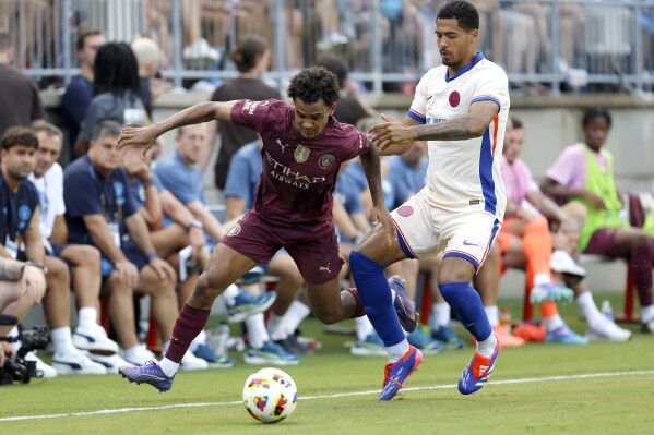 Manchester City's Oscar Bobb, left, works the ball past Chelsea's Levi Colwill, right, during an FC Series soccer match, Saturday, Aug. 3, 2024, at Ohio Stadium in Columbus, Ohio. (AP Photo/Tom E. Puskar)