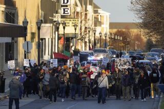 FILE - Protesters march in Kenosha, Wis., on Sunday, Nov. 21, 2021. On Tuesday, jan. 25, 2022, Wisconsin Assembly Republicans are poised to vote on bills that would create tougher penalties for protesters. One proposal would make attending a riot or blocking a street a misdemeanor punishable by up to nine months in jail and participating in a riot that causes property damage or personal injury a felony punishable by up to three-and-a-half years in prison. Anyone who harms or throws a bodily substance at a National Guard member would be guilty of a felony punishable by up to three-and-a-half years in prison. (AP Photo/Paul Sancya, File)
