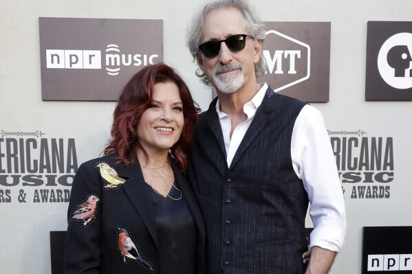 FILE - Rosanne Cash, left, and John Leventhal arrive at the Americana Honors and Awards show Wednesday, Sept. 12, 2018, in Nashville, Tenn. Leventhal has won six Grammys for songwriting and producing. And now, at 71, he's releasing an album of his own music, some of which features wife Rosanne Cash. (AP Photo/Mark Zaleski, File)