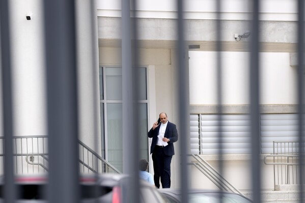 FILE - Yiannis Habaris, the lawyer for three of five Israelis who are accused of raping a British woman, speaks on his cellphone outside the Famagusta District Courthouse in Paralimni, Cyprus, on Tuesday, Sept. 12, 2023. Five Israelis accused of gang raping a British woman in a Cyprus hotel room won’t plead to charges including rape, sexual assault and abduction until prosecutors hand over key material including DNA tests, fingerprints and eyewitness testimony, lawyer Yannis Habaris said Thursday, Oct. 5, 2023. (AP Photo/Petros Karadjias, File)