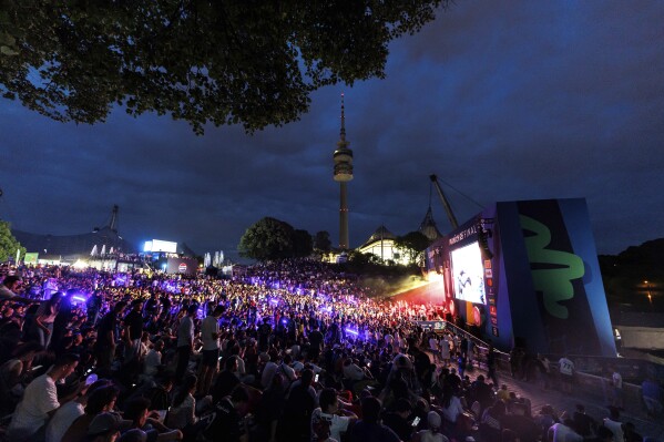 Fans watch a broadcast of the Champions League final soccer match between Paris Saint-Germain and Inter Milan at the Fan Zone in Olympic Park, Saturday, May 31, 2025, in Munich, Germany. (Matthias Balk/dpa via AP)