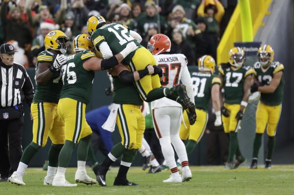 Green Bay Packers' Aaron Rodgers is congratulated after throwing career touchdown pass 443 during the first half of an NFL football game against the Cleveland Browns Saturday, Dec. 25, 2021, in Green Bay, Wis. The pass breaks the previous Green Bay Packers record held by Brett Favre. (AP Photo/Matt Ludtke)