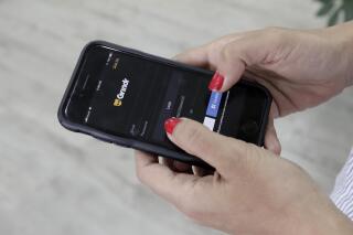 FILE - A person looks at the Grindr app on her mobile phone in Beirut, Lebanon, May 29, 2019. On Thursday, March 23, 2023, The Associated Press reported on false claims that Grindr said it would expose high-profile Republican users. (AP Photo/Hassan Ammar, File)