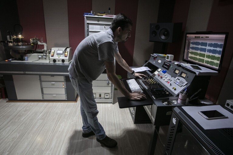 Sound operator William Carvalho prepares the audios to start cutting an album, part of the first stage of vinyl production at the Polysom factory, in Belford Roxo, Brazil, Tuesday, April 16, 2024. In 2008, producer João Augusto and his partners bought and resuscitated Polysom, then a former vinyl pressing plant. Fifteen years later, Polysom has pressed 1.3 million records and competitors opened two other factories in Brazil. (AP Photo/Bruna Prado)