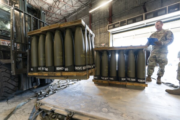 FILE - U.S. Air Force Staff Sgt. Cody Brown, right, with the 436th Aerial Port Squadron, checks pallets of 155 mm shells ultimately bound for Ukraine, April 29, 2022, at Dover Air Force Base, Del. On Sept. 15, 2023, The Associated Press reported on a false claim online that the U.S. accidentally sent Ukraine $6 billion in military aid. The claim misrepresents remarks by a Pentagon spokesperson. (AP Photo/Alex Brandon, File)