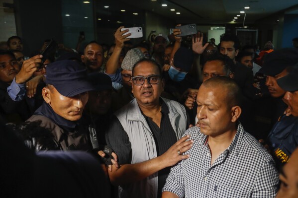 Kailash Sirohiya, center, the owner of Nepal's largest news organization is taken away by police after being arrested from the office of Kantipur Publications, in Kathmandu, Nepal, Tuesday, May 21, 2024. Sirohiya, was arrested for allegedly violating the country's citizenship laws over an issue with his citizenship card. (AP Photo/ Sujan Gurung)