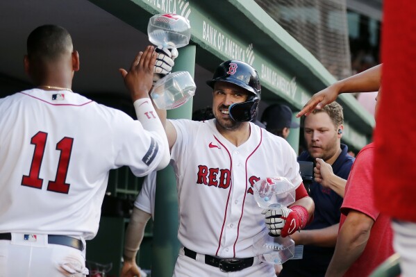 Boston Red Sox's Adam Duvall, center, celebrates after his three-run home run with Rafael Devers (11) during the sixth inning of a baseball game against the Los Angeles Dodgers, Saturday, Aug. 26, 2023, in Boston. (AP Photo/Michael Dwyer)