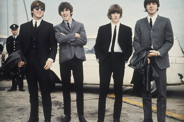 FILE - The Beatles, from left, John Lennon, George Harrison, Ringo Starr and Paul McCartney arrive in Liverpool, England on July 10, 1964, for the premiere of their movie 