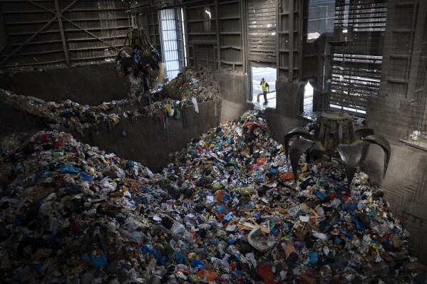 FILE - Cranes lift waste, mostly plastic and paper at the GreenNet recycling plant in Atarot industrial zone, north of Jerusalem, Jan. 25, 2023. (AP Photo/Oded Balilty, File)