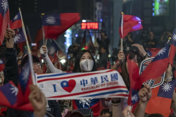 In this photo taken Saturday, Jan. 11, 2020, supporters of the Nationalist or KMT party cheer with the Taiwanese flag during the presidential election in Kaohsiung, Taiwan. About two-thirds of Taiwanese don't identify as Chinese, according to a survey released Tuesday, highlighting the challenge China faces to bringing the self-governing island under its control. The U.S.-based Pew Research Center found that 66 percent view themselves as Taiwanese, 28 percent as both Taiwanese and Chinese and 4 percent as just Chinese. (AP Photo/Ng Han Guan)
